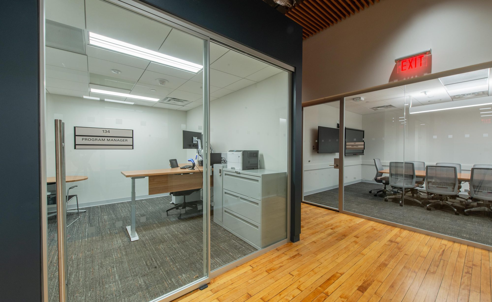 New glass-fronted offices and conference room on refinished historic hardwood flooring