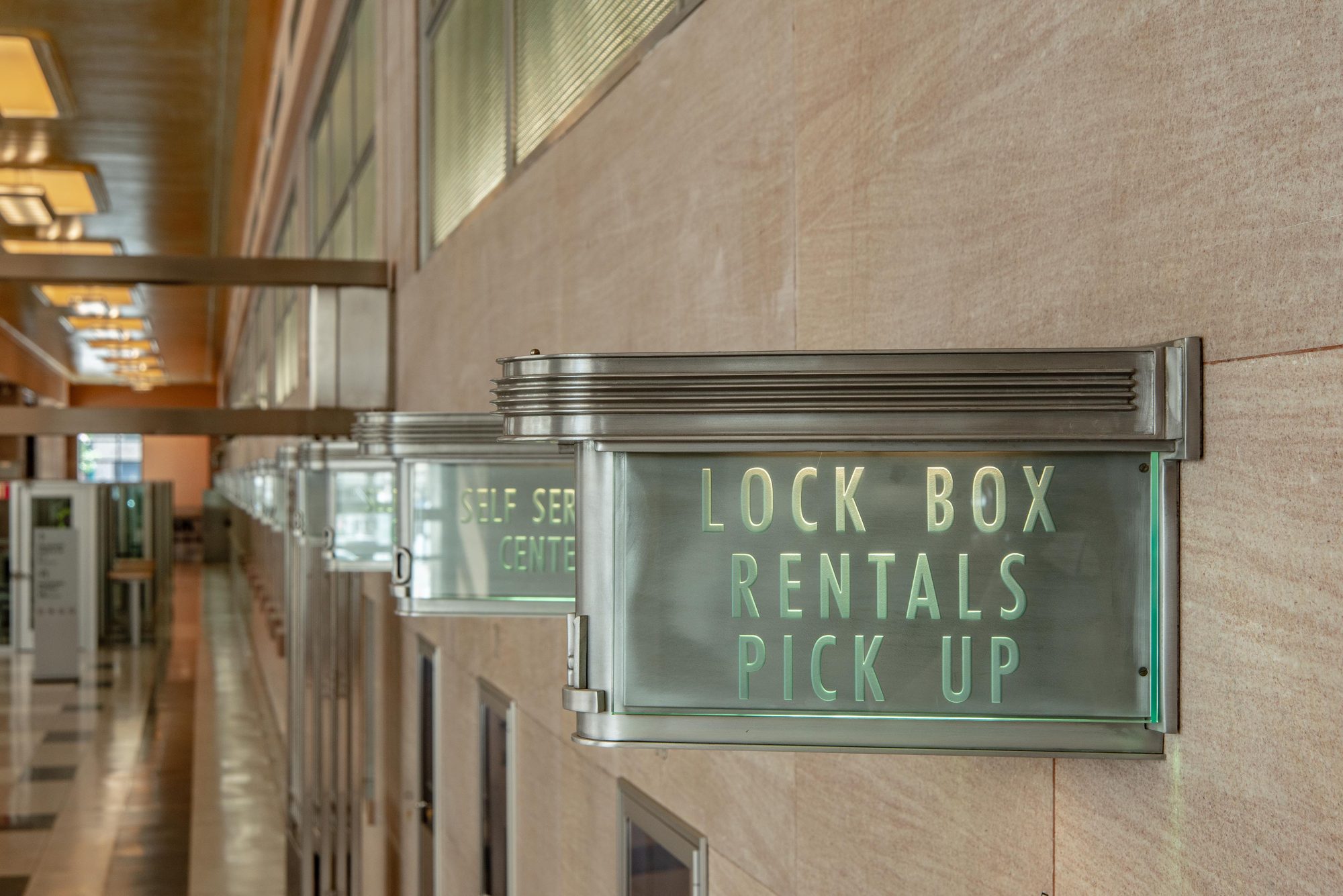 Restored historic metal lock box and self-service signs along the lobby wall